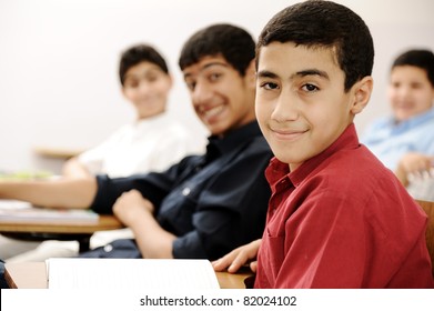 Happy children with their teacher in classroom, doing schoolwork
