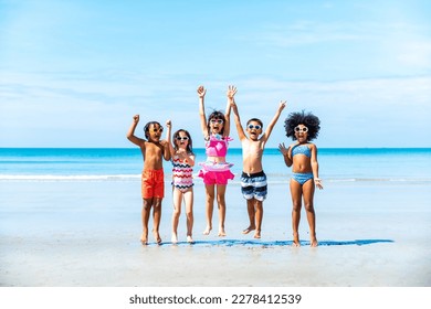 Happy children travel and playing at the beach on summer holiday vacation. Group of Little child boy and girl kids enjoy and fun outdoor lifestyle running and playing in the sea at tropical island. - Powered by Shutterstock