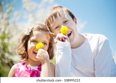 Happy children wearing clown noses looking down on the camera. Playful noses from a dandelions