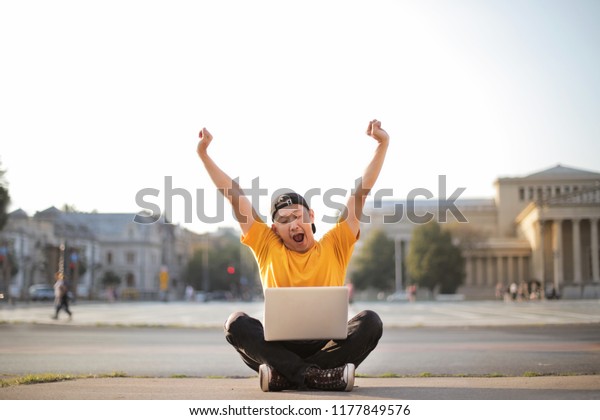 Happy Chinese guy with\
laptop.