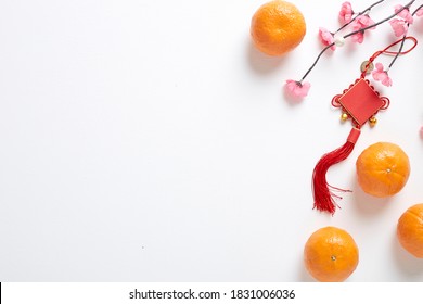 Happy Chinese New Year 2021 Or Lunar New Year  Decoration Festival Top View Pendant Ornaments Knot And Pink Cherry With Orange Fruit On White Wooden Table