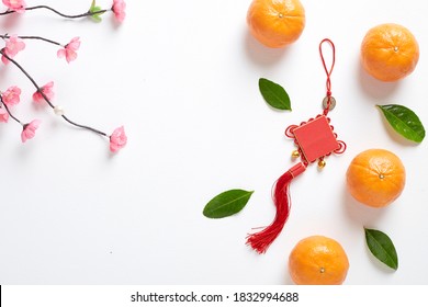 Happy Chinese New Year 2021 Or Lunar New Year  Decoration Festival Top View Pendant Ornaments Knot And Pink Cherry With Orange Fruit On White Wooden Table