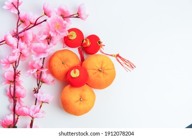 Happy Chinese New Year 2021 Or Lunar New Year Flat Lay Decoration Festival Red Pendant Ornaments Knot, Mandarin Orange Fruit And Pink Cherry. Copy Space Concept