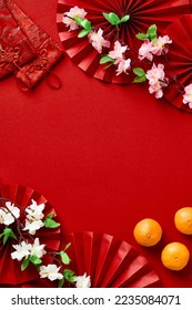 Happy Chinese New Year 2023 year of the rabbit concept. Chinese New Year banner design with tangerines, blossom flowers, money pockets, oriental asian paper fans on red background - Shutterstock ID 2235084071