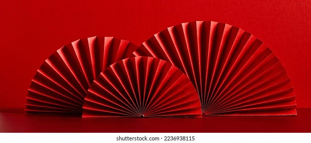 Feliz Año Nuevo Chino 2023, año del concepto de conejo. Aficionados de papel de estilo oriental asiático sobre una mesa roja. Estilo minimalista.