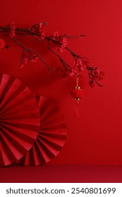 Happy Chinese New Year 2025, year of the snake concept. Vertical banner design with red paper fans and cherry blossom branches on red background