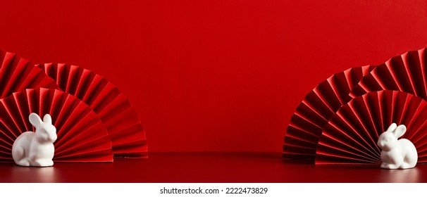 Happy Chinese New Year banner template. Red paper fans with rabbit decorations on red background. Traditional holiday lunar New Year. Happy New Year of the rabbit.