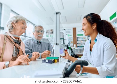 Happy Chinese pharmacist advising senior couple in choosing vitamins in drugstore.  - Powered by Shutterstock