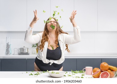 Happy Chubby Girl Scattering Spinach Leaves All Over The Table. Overweight Girl Happy Loosing Weight Eating Fresh Salad. Curvy Body Young Woman With Long Blond Hair. Dieting And Nutrition Concept. 