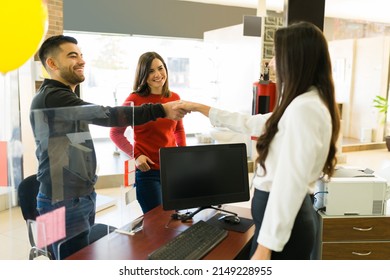 Happy Clients At The Store. Excited Young Woman And Man Speaking With A Salesperson At The Furniture Store 