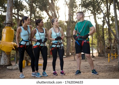 Happy coach and trainee interacting with each other in forest - Powered by Shutterstock