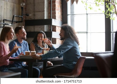 Happy  colleagues gather in pizzeria or bar have fun talking eating pizza, smiling  diverse friends hang out in cafe enjoying tasty Italian food, relaxing on weekend together - Powered by Shutterstock