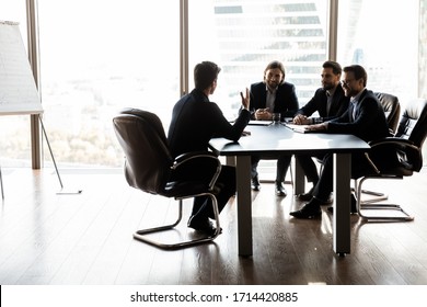 Happy colleagues having fun at meeting in boardroom, sitting at table together, sharing ideas, discussing project strategy, smiling satisfied hr managers listening to successful job candidate