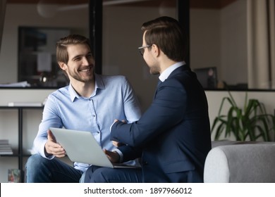 Happy colleagues shaking hands, greeting or making agreement, sitting in office with laptop, manager and client handshake, successful deal, hr manager recruiter congratulating candidate, getting job - Shutterstock ID 1897966012