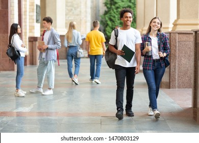 Happy college classmates walking in campus during break and communicating, copy space - Shutterstock ID 1470803129