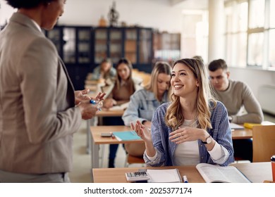 Happy College Student And Her Professor Communicating During Lecture In The Classroom.