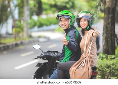 Happy Commercial Motorcycle Taxi Driver And His Passenger Showing Thumb Up To Camera