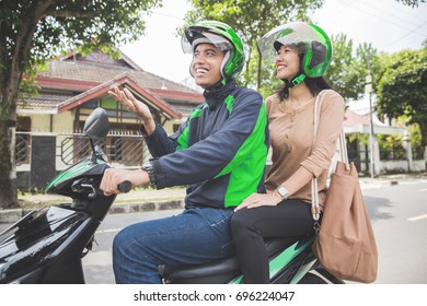 Happy Commercial Motorcycle Taxi Driver Taking His Passenger To Her Destination