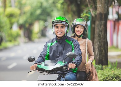 Happy Commercial Motorcycle Taxi Driver Taking His Passenger To Her Destination