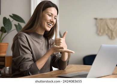 Happy communication expert speaking to patient with hearing disability online, showing thumb up on palm at computer, smiling, laughing. Sign language therapist using Internet for communication - Powered by Shutterstock