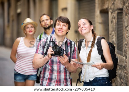 Happy company of impressed travelers during city walking
