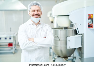 Happy Confectionery Factory Employee Standing In White Coat With Arms Crossed And Looking At Camera. 