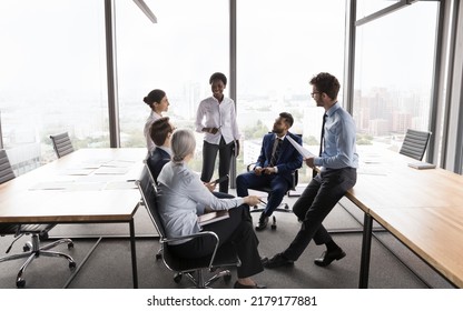 Happy Confident African American Business Coach Training Interns. Female Leader Meeting With Diverse Team In Open Office Interior With Glass Wall, Talking To Employees, Laughing