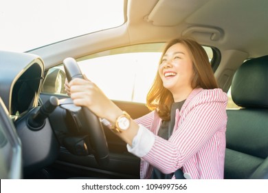 Happy confident and beautiful women,young asian businesswoman in casual wear,she smiling while driving a car against sunset rays Light shine sky Concept  