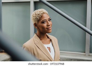 Happy confident black businesswoman by the steps