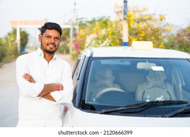 Happy confident cab driver with crossed arms standing next to car by looking at camera - concept of self-employed, positive emotion and profesional occupation.