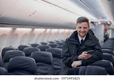 Happy confident caucasian pilot in airplane salon - Shutterstock ID 1971491825