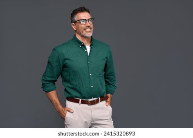 Happy confident cool middle aged business man, smiling mature professional businessman wearing green shirt and stylish eyeglasses looking aside standing isolated on gray background. - Powered by Shutterstock