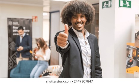 Happy confident creative businessman showing thumbs up in office - Powered by Shutterstock