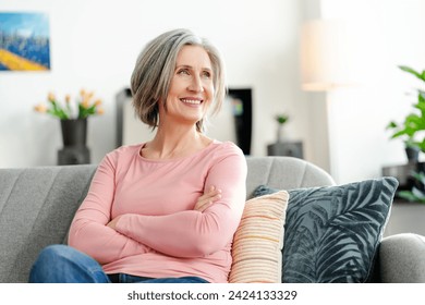 Happy confident senior woman holding arms crossed sitting on comfortable sofa at home. Portrait smiling retired female with stylish gray hair, white teeth. Natural beauty, healthy lifestyle concept  - Powered by Shutterstock