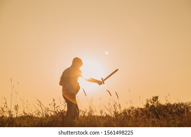 Happy Confident Young Kid Playing Outdoor In Summer Sunny Sunset Landscape. Setting Goals And Aims Concept. Horizontal Color Photography.