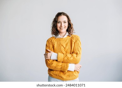 Happy, confident young woman with curly hair smiling at the camera. Isolated against a white background, perfect for advertising, promotions, and commercial use. Bright and cheerful vertical portrait. - Powered by Shutterstock