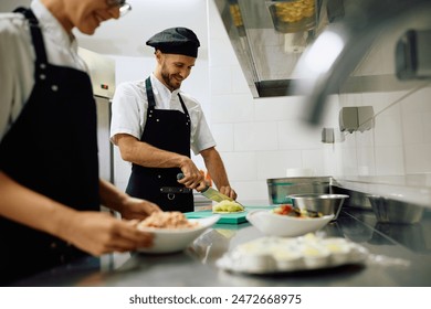 Happy cook preparing food while working in the kitchen in restaurant.  - Powered by Shutterstock