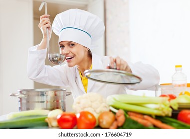 Happy  Cook In Uniform Tests  Soup With Ladle At Commercial Kitchen  