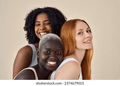 Happy cool pretty fashion gen z girls in underwear looking at camera, beauty portrait. Three smiling diverse young women, multicultural ladies models faces bonding isolated on beige background. Stock Photo