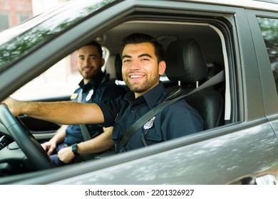 Happy Cop Agent Smiling While On Patrol In The Police Car On The Street And Enjoying Law Enforcement