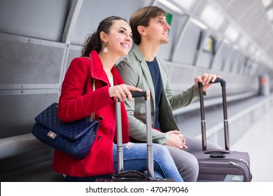 Happy Couple 25-35 Years Old Sitting At Underground Platform Awaiting Train