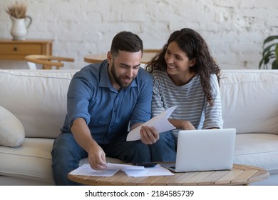 Happy Couple Of 30s Renters, Homeowners Doing Domestic Accounting Job, Household Paperwork, Reviewing Paper Documents At Laptop Computer, Calculator, Paying Bills, Mortgage, Rent Fees On Internet