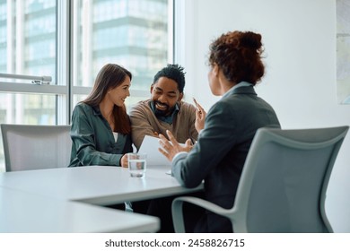 Happy couple analyzing contract while having a meeting with their financial advisor in the office. 