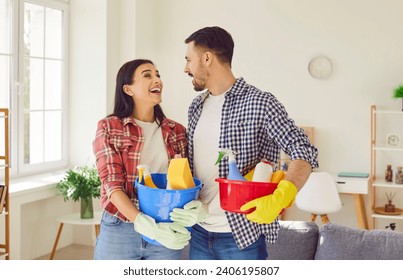 Happy couple, armed with cleaning equipment, bringing joy to the living room. Family showing fun teamwork and shared responsibility, where household chores become moments of connection. - Powered by Shutterstock