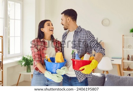 Happy couple, armed with cleaning equipment, bringing joy to the living room. Family showing fun teamwork and shared responsibility, where household chores become moments of connection.