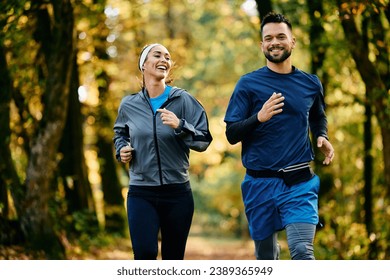 Happy couple of athlete running in the park in autumn. Copy space. - Powered by Shutterstock