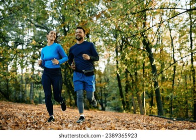 Happy couple of athletes running in autumn day in nature. Copy space.  - Powered by Shutterstock