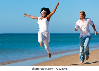 Happy Couple - Black Woman And Caucasian Man - Walking And Running Down A Beach In Their Vacation