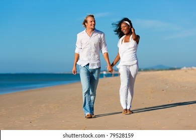 Happy Couple - Black Woman And Caucasian Man - Walking And Running Down A Beach In Their Vacation