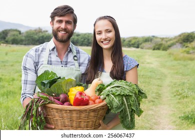 Happy couple with box of veg on a sunny day